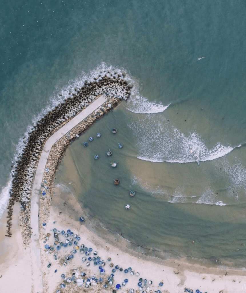 The peaceful Ong Dia rock beach is adorned with the colorful array of basket boats.